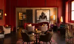 Lounge area with chairs and tables, bold photographic artwork on the wall