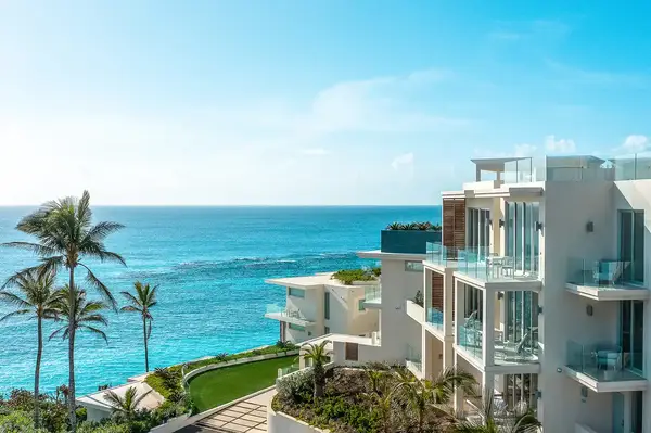 Oceanfront view with modern residential buildings and palm trees