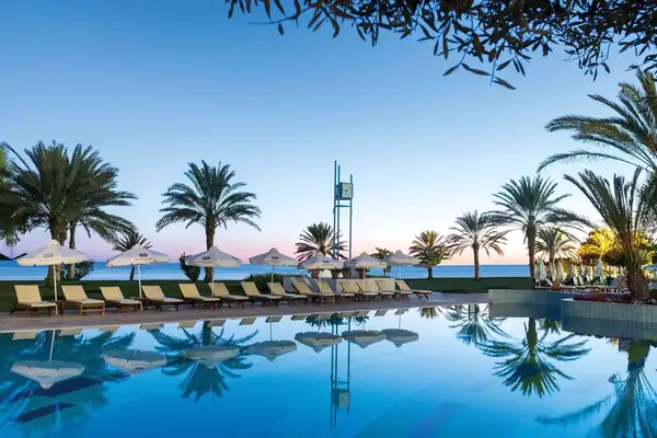 Lounge chairs by a pool under palm trees