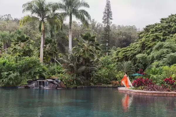 A woman walking along a lagoon at Sensei Lanai 
