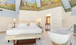 Bedroom with a freestanding bathtub and a painted ceiling