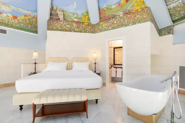 Bedroom with a freestanding bathtub and a painted ceiling