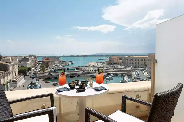 Terrace view with seating overlooking a marina in an urban area