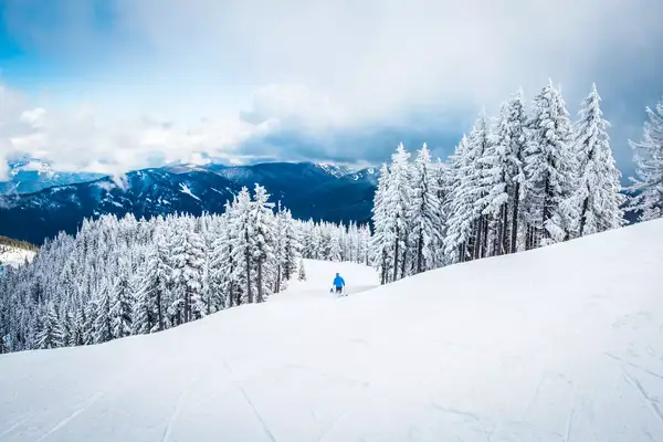 A skier going down a snowy mountain
