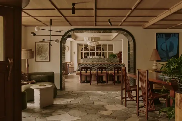 A communal area with an archway, seating arrangements, and a dining area in the background