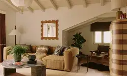 Living room with a sectional sofa, coffee table, mirror, and plant near the window in a bright space