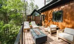 Outdoor patio with seating and table overlooking forest treetops