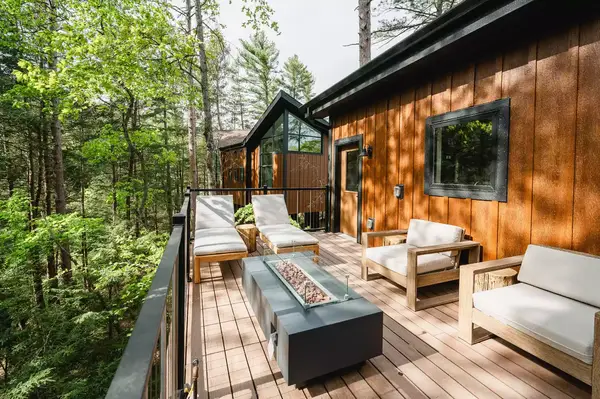 Outdoor patio with seating and table overlooking forest treetops