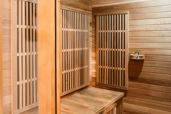 Wood-paneled sauna interior with a bench and vertical slats on the walls