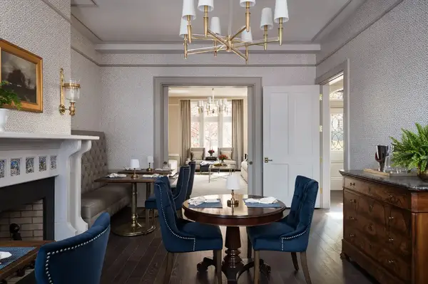 An elegant dining room setup with tables chairs and a visible doorway leading to another space