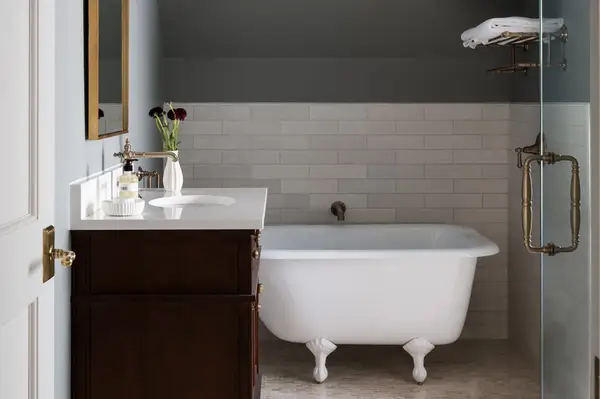 A bathroom with a freestanding bathtub a wooden vanity and a glass shower enclosure