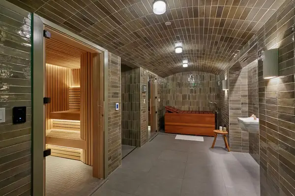 Spa room featuring a sauna, wooden soaking tub, and tiled walls
