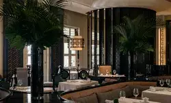 Elegant dining room with tables set and indoor palm decorations