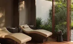 Lounge chairs in a spa setting next to a window with garden view