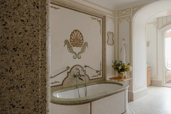 Elegant bathroom with a classic-style bathtub and decorative walls, part of a luxurious hotel suite
