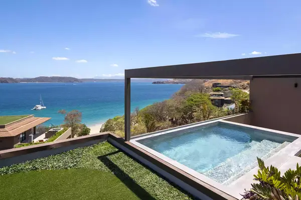 Rooftop pool at a resort overlooking the ocean and surrounding landscape