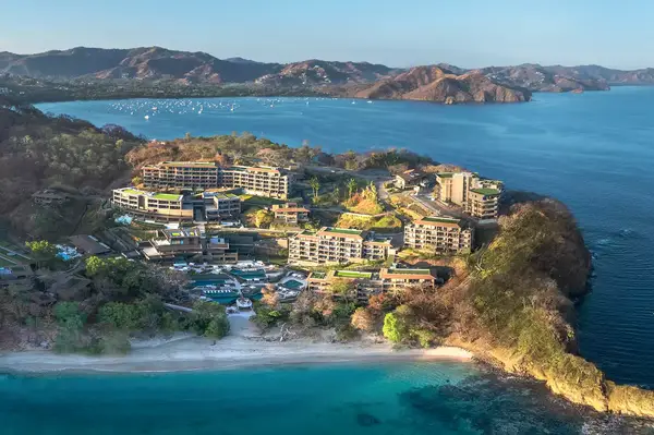 Aerial view of Waldorf Astoria Punta Cacique, resort with buildings, beach, and coastline in the background