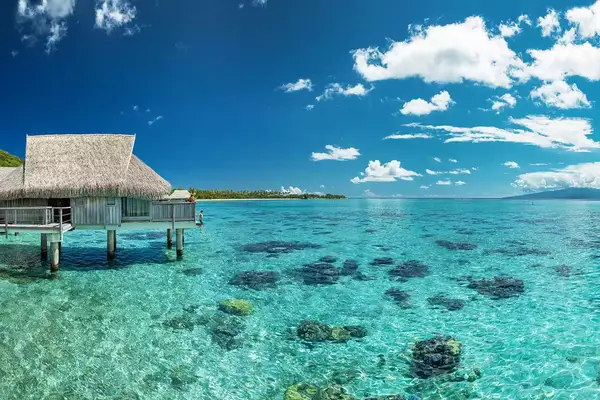 A guest on an overwater bungalow terrace at Sofitel Kia Ora Moorea