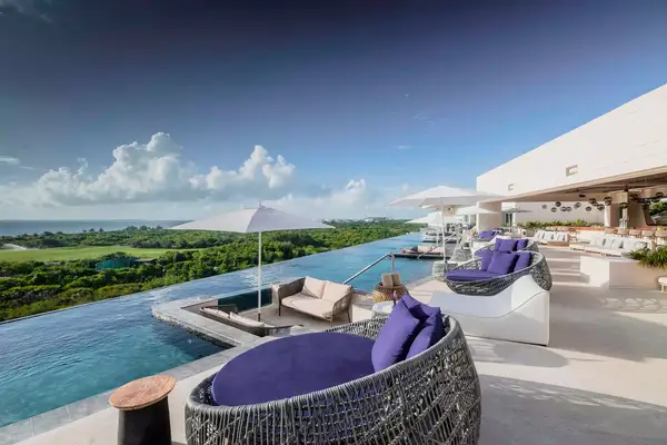 A pool overlooking a forest at Atelier Playa Mujeres