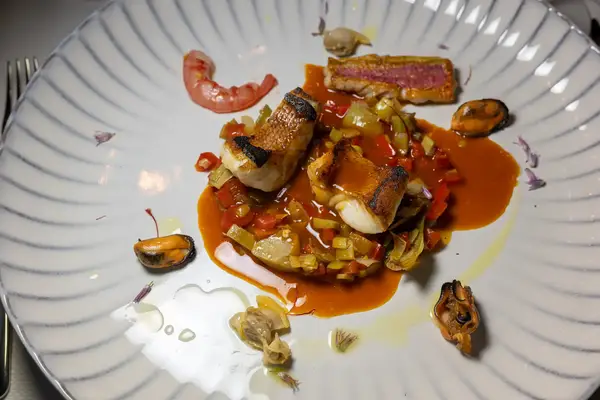 A gourmet seafood dish arranged artfully on a white plate