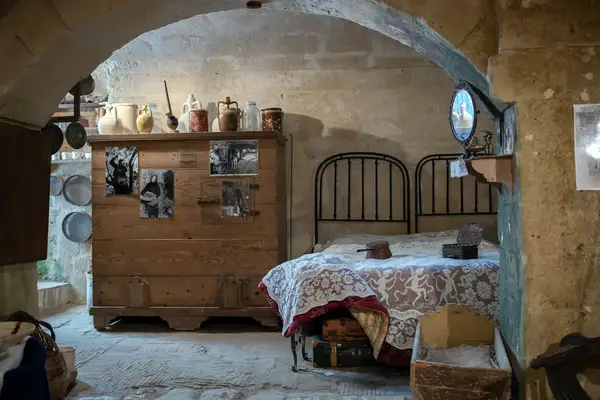 A rustic room setup with a bed, a wooden chest, and decorative items