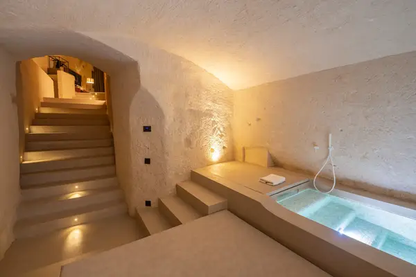 Luxurious stone room with stairs, a pool, and soft lighting