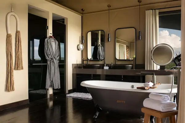 Luxury bathroom with a freestanding bathtub and robes hanging near the sink area showcasing a relaxing and elegant setting