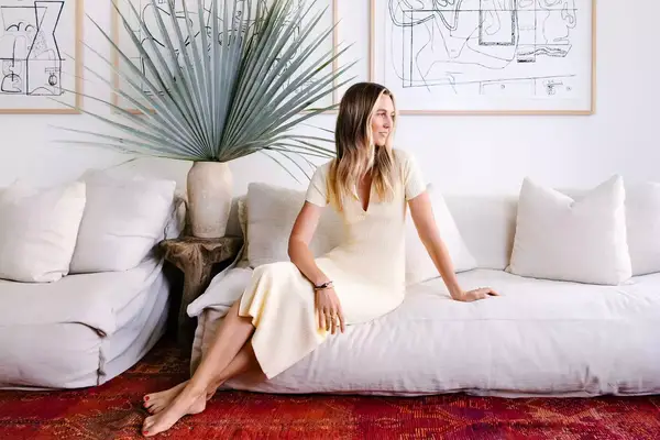 Hotelier Emma Goodwin sits on a sofa in the library of her Surfrider Hotel, in Malibu