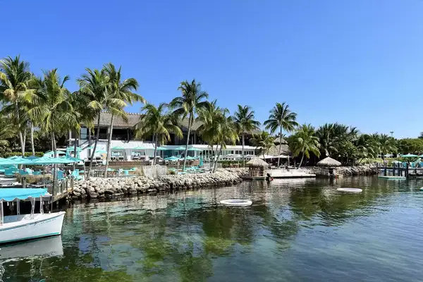Exterior view of Bungalows Key Largo resort with palm trees and turquoise and white decor 