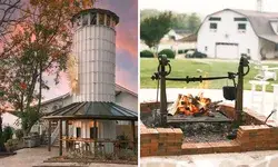 A farm building with a silo on one side and an outdoor fire pit with a grill on the other, part of a rural setting and seating area