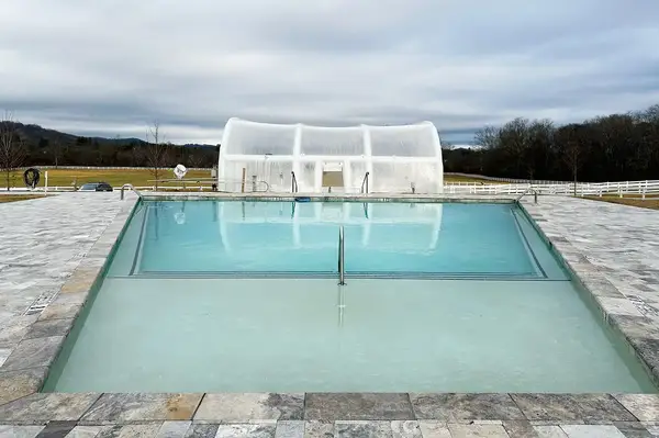 Outdoor pool with view of a white domed structure in a grassy landscape at Horse Shoe Farm, North Carolina