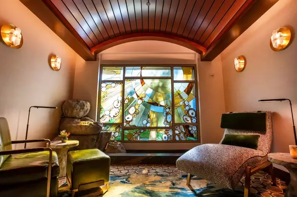 A luxurious spa relaxation lounge with seating and a decorative stained-glass window