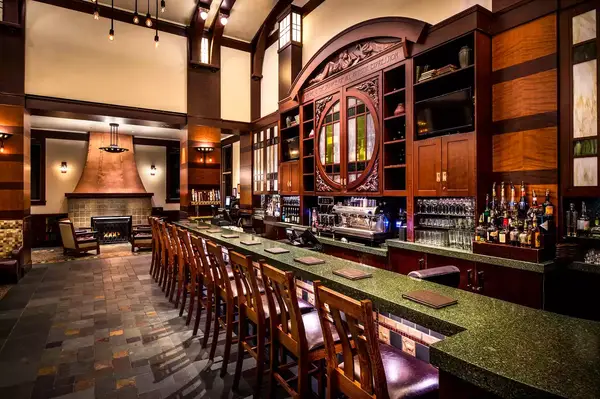 Upscale bar with wooden chairs and a fireplace, elegant interior design