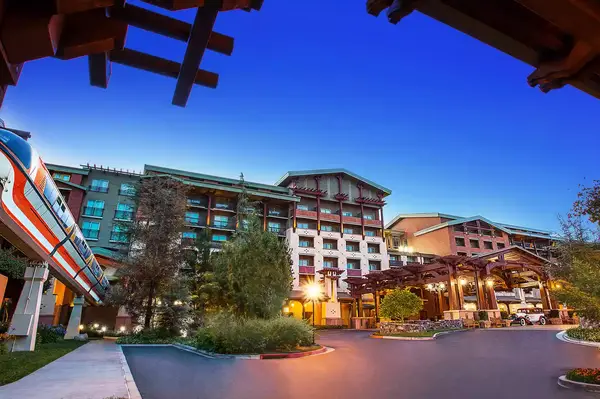 View of the Grand Californian Hotel with Disneyland Monorail passing by, depicting the exterior and surrounding greenery