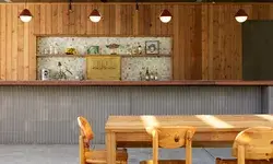 Outdoor bar setup, wooden paneling, with a visible table and chairs in the foreground