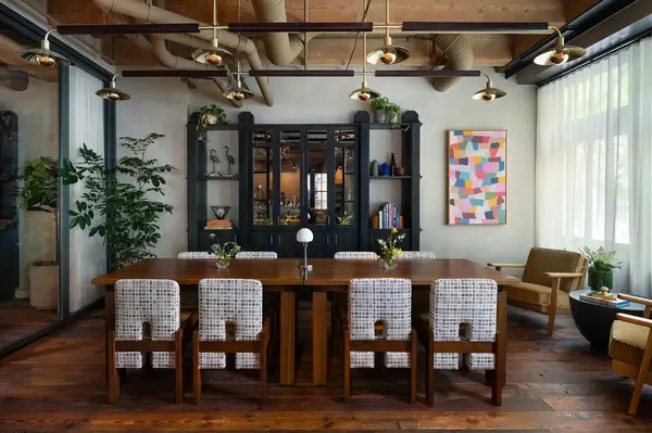 A dining room setup in a private meeting space with decorative furnishings and art