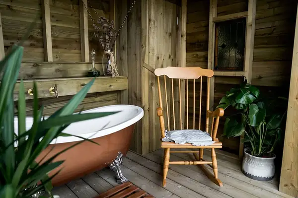 Wooden interior room with a bathtub plant and chair