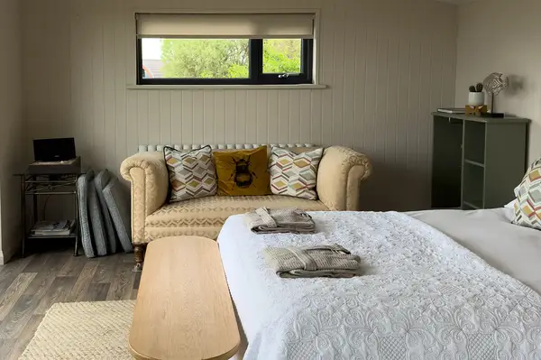 Hotel room interior with a bed sofa and window