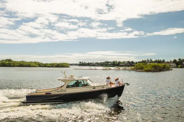 A boat cruising on water near a coastal area, people visible on the boat