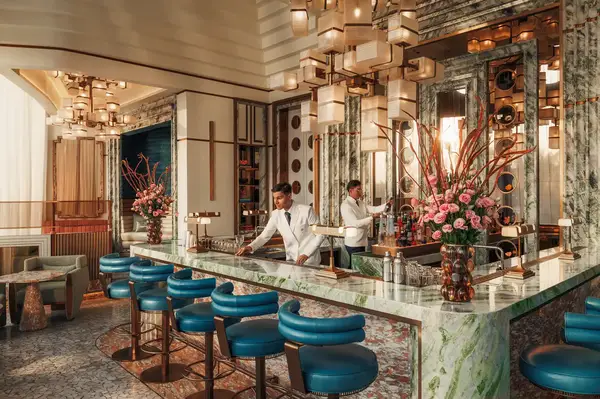 Upscale hotel bar interior with a bartender preparing drinks featuring luxurious furnishings and artistic dcor