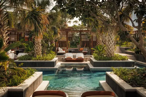 A luxurious pool area surrounded by tropical landscaping and private cabanas