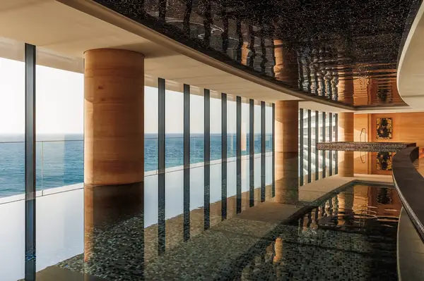 Interior of a luxurious pool area with large windows overlooking the sea