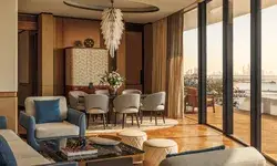 Luxury dining and living area with large windows overlooking a cityscape featuring stylish furniture and elegant decor