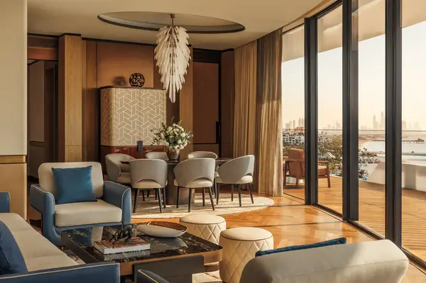 Luxury dining and living area with large windows overlooking a cityscape featuring stylish furniture and elegant decor