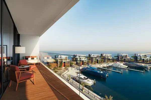 View from a balcony overlooking a marina with yachts and modern villas