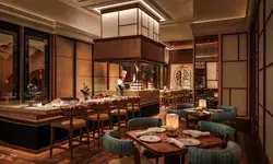 Modern restaurant interior with dining tables chairs a counter with a chef and decorative lighting