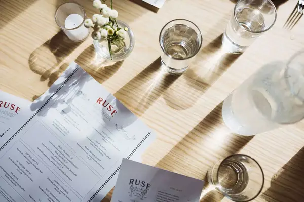 Dinner menu and water glasses at Ruse, apart of The Wildset Hotel