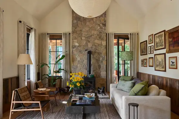 A cozy cabinstyle living area with a stone fireplace seating and decor emphasizing natural elements