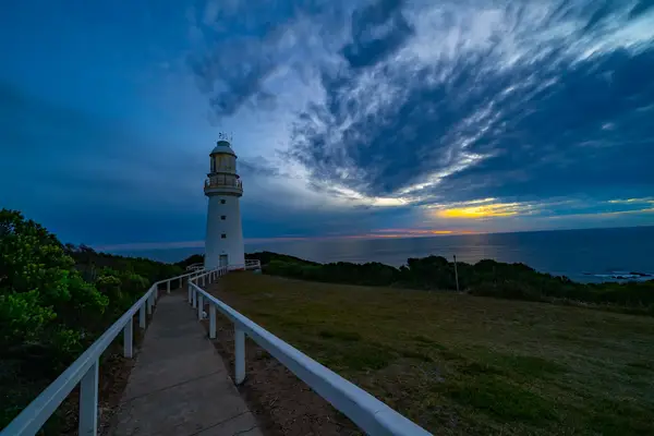 Historic Cape Otway Lightstation in southwest Victoria, Australia, under a dramatic cloudy sky at sunset