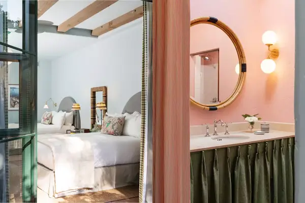 The bed and bathroom in a Palihouse Santa Barbara guest room 